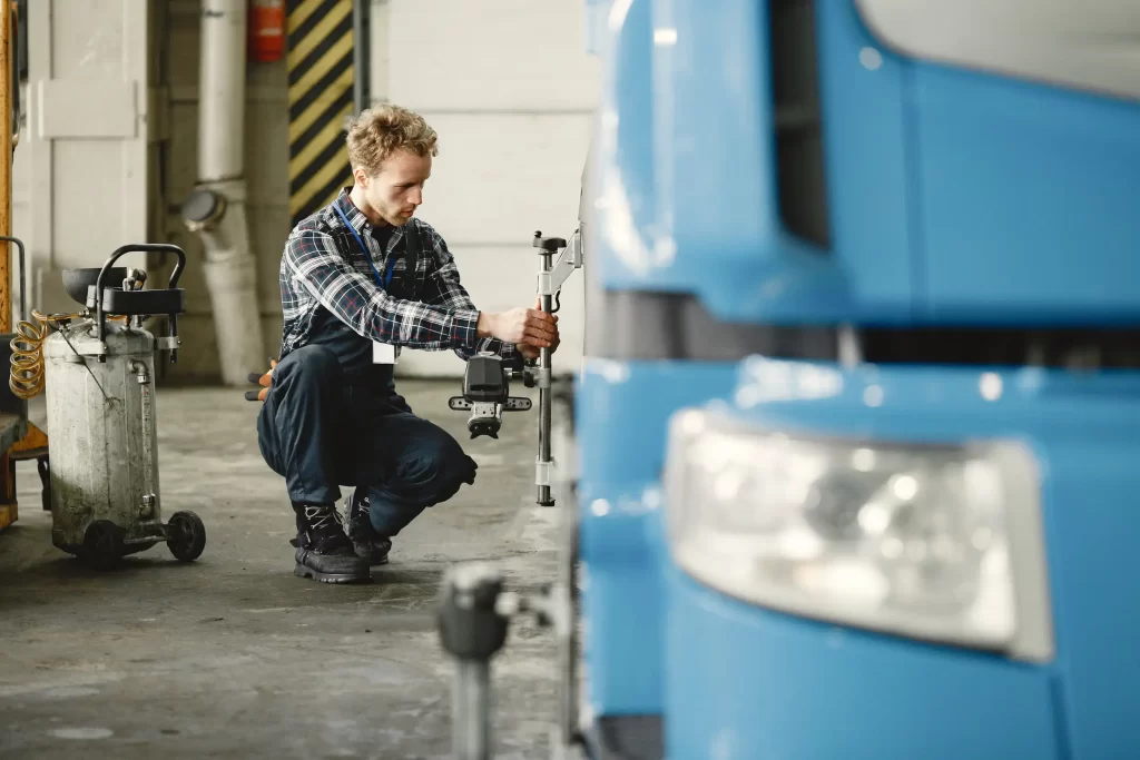 A professional mechanic checking and measuring the the tires of a truck.