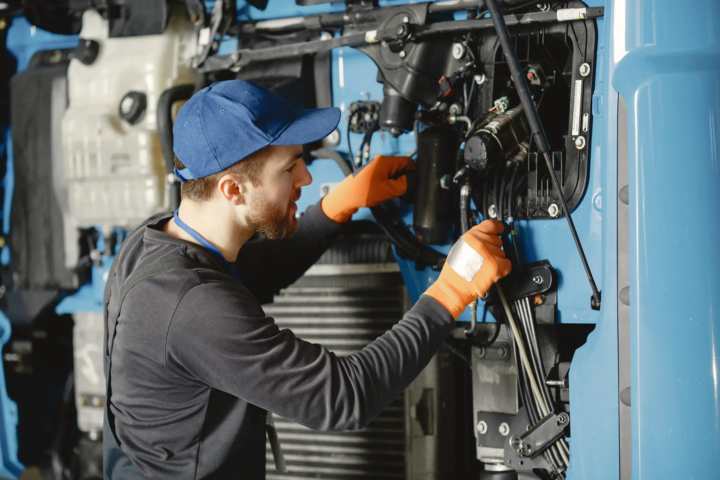 A working mechanic checking the wiring and the condition of a trailer truck.