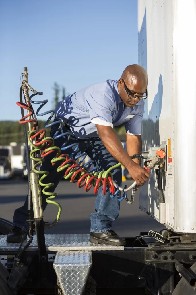 Technicians working on trailer repair for electrical system.