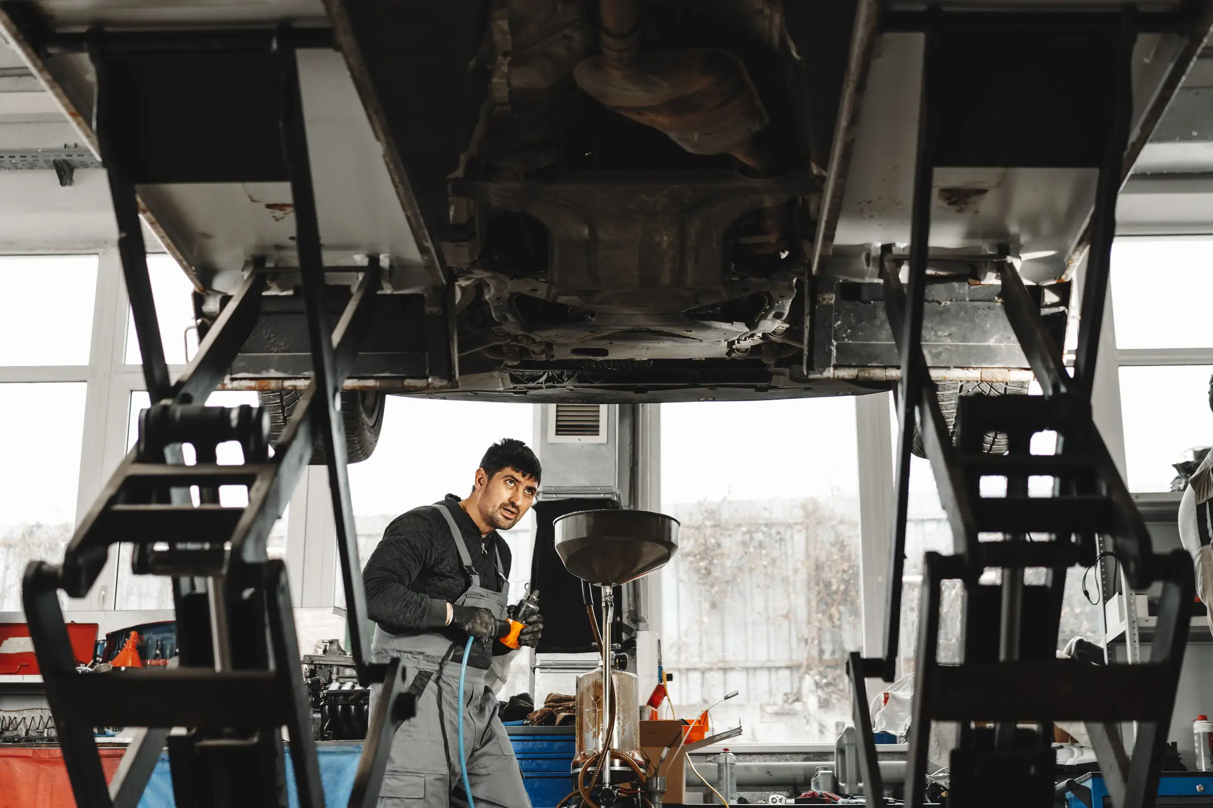 A technician checking for problems and damages of the truck suspensions.