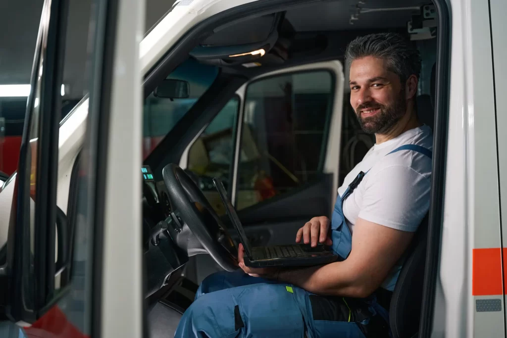 A man smiling with an a truck door opened.