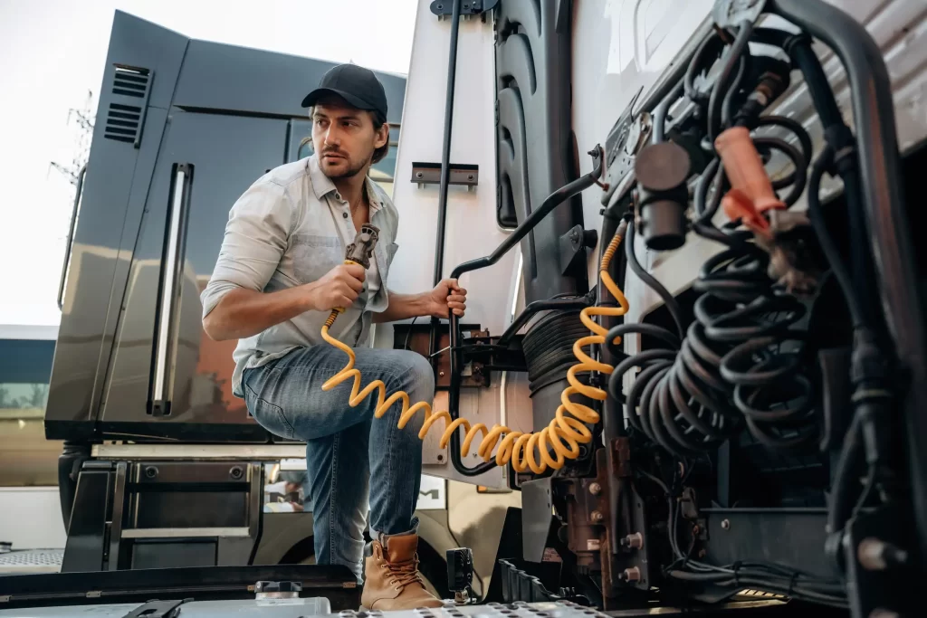 Driver checking the cables of the trailer truck.