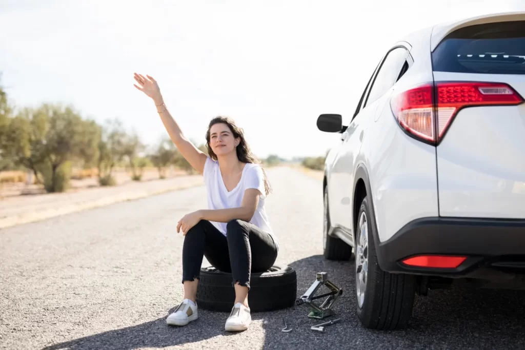 A woman waiting for her assistance on the road.