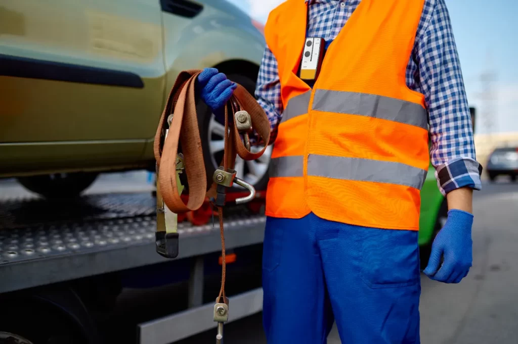 A man ready to tow a car that is stuck on the road.