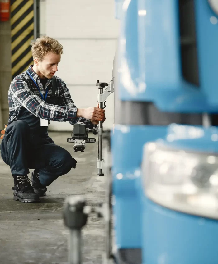 A professional mechanic checking and measuring the the tires of a truck.