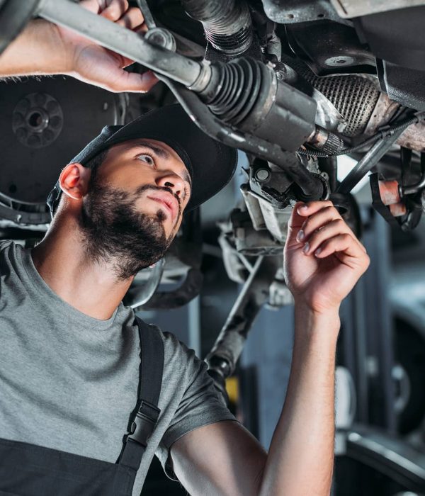 A mechanic repairing under a trailer truck.